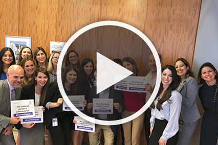 Group holding signs with play button