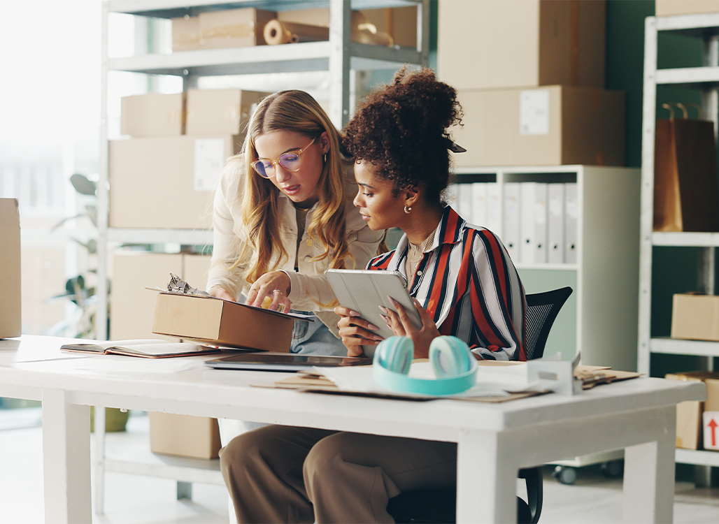 Two business women looking at a clipboard
